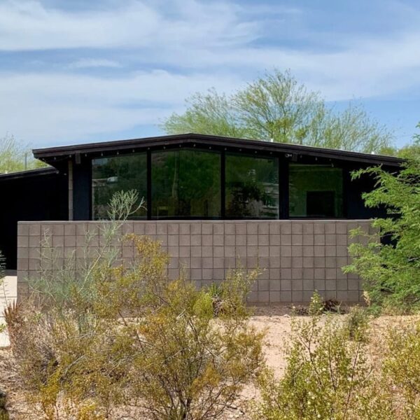 Ralph Haver mid-century modern home in Marion Estates Phoenix with block privacy wall, low roofline, glass corner windows, desert landscaping, and mountain views.