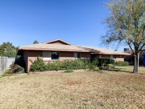 Original Scottsdale ranch home before renovation showing low rooflines, enclosed facade, and traditional landscaping.