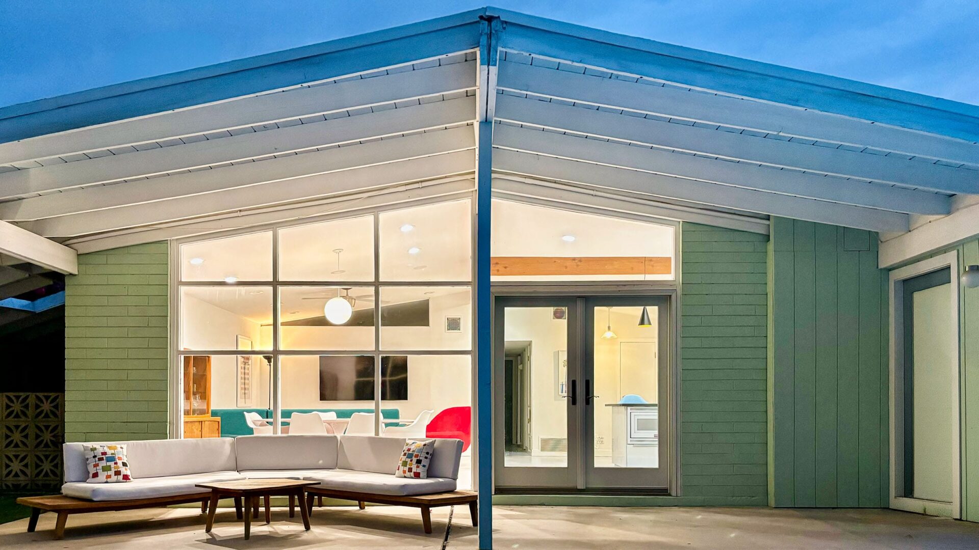 Mid-century modern patio in Scottsdale at evening with warm lighting, outdoor seating, and desert modern atmosphere.