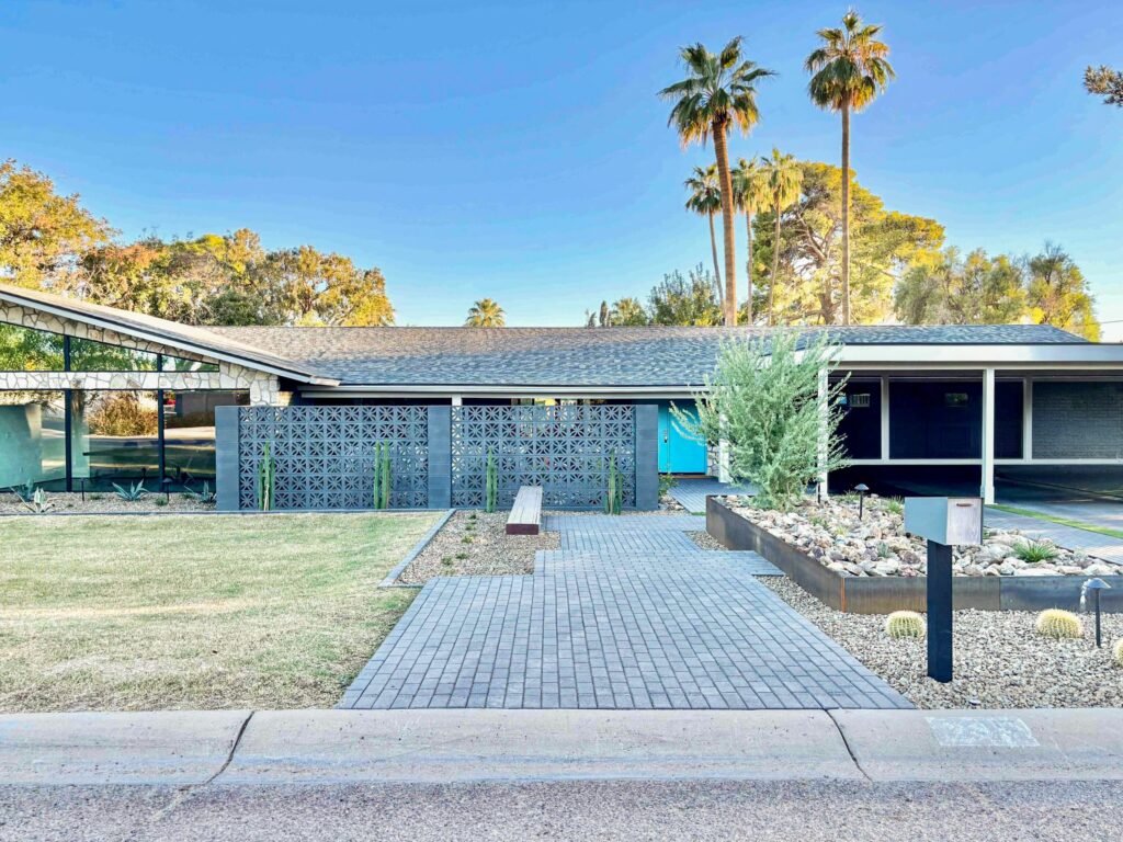 Renovated front entry at Rose Lane featuring decorative shadow block screening, paver walkway, steel planters, desert landscaping, and modernized mid-century architecture in Phoenix, Arizona.