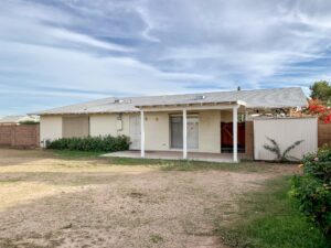 Backyard of the Sheridan House in Scottsdale before renovation showing an undeveloped yard and existing rear elevation.