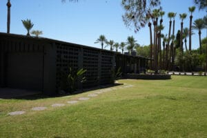 Black-painted mid-century modern home in Phoenix with breeze block, low roofline and dark exterior finishes.